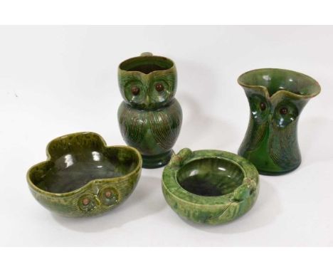 Two Farnham Pottery green-glazed owl jugs, circa 1900, 14.5cm and 16.5cm high, a similar Brannam for Liberty owl bowl, and an