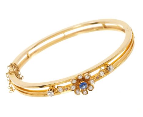 Late Victorian gold hinged bangle with a blue sapphire and seed pearl flower flanked by two old cut diamonds on openwork hing
