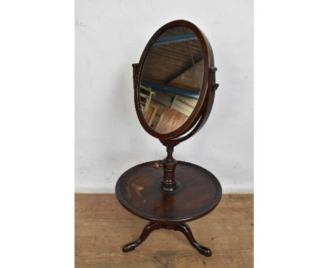 George III mahogany shaving stand, with oval hinged mirror plate rising on adjustable thread from dished stand and tripod bas