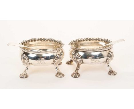 Two matching George III silver salts of oval form, with gadrooned borders and engraved armorial crests, on stylised shell fee