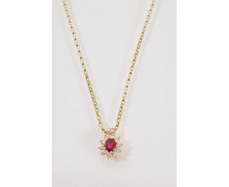 Ruby and diamond cluster pendant with an oval mixed cut ruby measuring approximately 5 x 4 mm surrounded by ten brilliant cut
