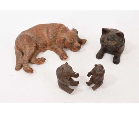Black Forest carving of a dog, in reclining pose, 16cm long, and other Black Forest carvings, including a kitten inkwell. (4)