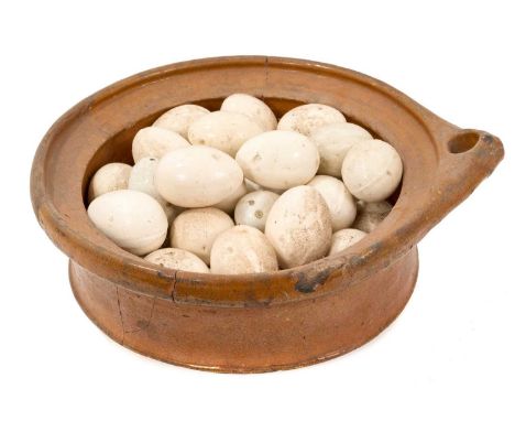 Collection of ceramic nesting hen eggs, approximately 30, housed in an early 17th century pottery bowl, with note stating it 