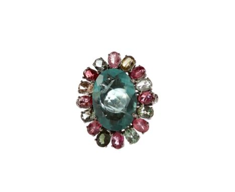 FLUORITE AND TOURMALINE RING, set with a central oval fluorite 19mm long, within a halo of coloured tourmalines, unmarked, li