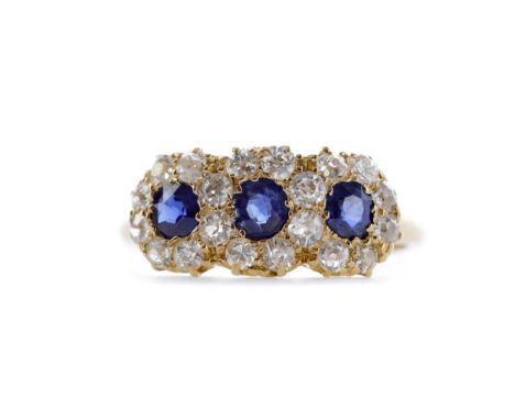 SAPPHIRE AND DIAMOND RING, set with three cushion cut sapphires totalling approximately 0.75 carats, bordered by old cut diam