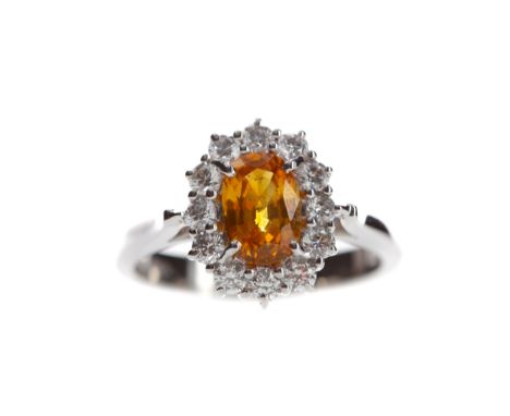 ORANGE SAPPHIRE AND DIAMOND RING, set with an oval orange sapphire of approximately 1.21 carats, within a halo of round brill