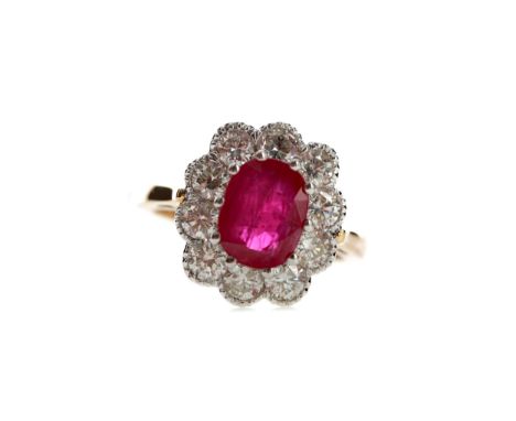 RUBY AND DIAMOND RING, set with an oval ruby of approximately 2.50 carats within a halo of round brilliant cut diamonds total