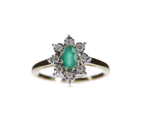 EMERALD AND DIAMOND RING, set with an oval emerald surrounded by illusion set diamonds totalling approximately 0.10 carats, m