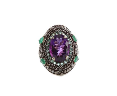 AMETHYST, EMERALD AND DIAMOND RING, set with an oval amethyst surrounded by round emeralds, with four pear shaped emeralds an
