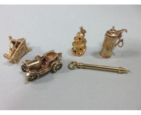 A small collection of quirky gold charms, the first a helter-skelter with hinged base revealing an enamelled figure, hallmark