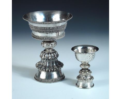 A Tibetan/Nepalese metalwares yak butter lamp of traditional form, 14.5cm high, 7.88oz together with another smaller basemeta