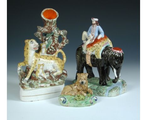 Three 19th century Staffordshire pottery figures, the 'Walton' lion reclining on a green mound, 8cm (3.25 in) high, the leopa