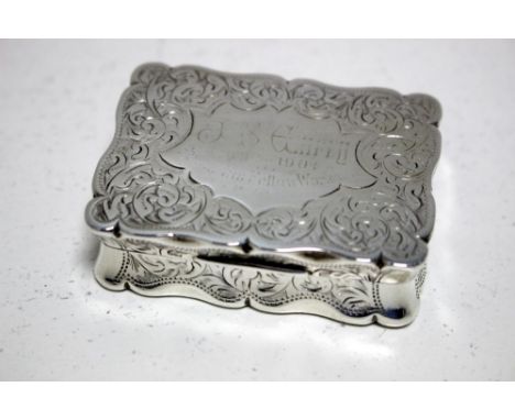 A small Edwardian silver snuff box, by William Aitken, Chester 1901, of rectangular shape with serpentine edges, the body flo