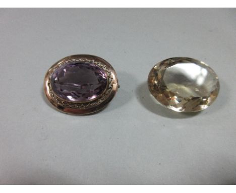 An amethyst brooch together with a large loose oval cut citrine, the brooch with an oval cut amethyst collet set to a pierced