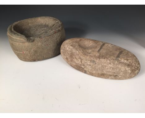 A Scottish neolithic grey stone 'quern' and a handstone, the rounded rectangular shape of the first dished and with lowered p