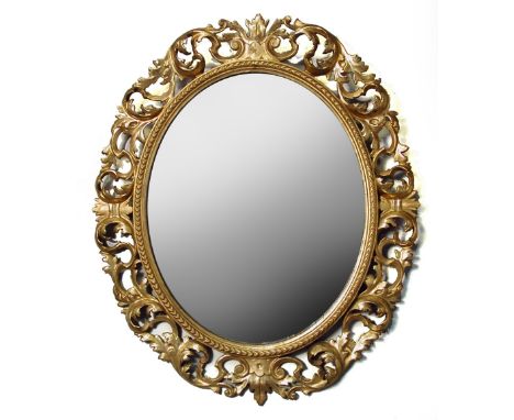 A 19th century Florentine gilt framed oval wall mirror, carved and pierced decoration 87 x 74cm (34 x 29in)  Evidence of some