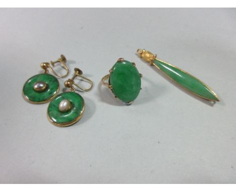 A jade ring, a pin brooch and a pair of earpendants, the ring with an oval cabochon jade claw set to a pierced gallery and pl