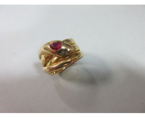A gemset snake ring, formed as a triple coil with head and tail to the front, with rose cut diamond eyes and a pear cut ruby 