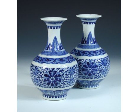 A pair of Chinese blue and white vases, each painted with leaf and lappet bands enclosing scrolling lotus on the compressed s