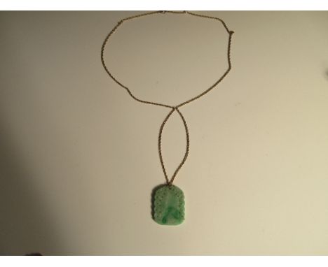 A carved jadeite jade pendant on a ropetwist chain, the mottled light green jade plaque carved on both sides to represent dra