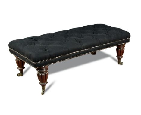 A 19th century long stool, button upholstered in black felt fabric, on gadroon moulded legs and brass casters 41 x 55 x 127cm