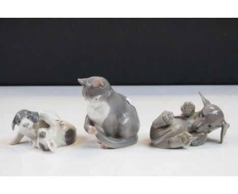 Three Royal Copenhagen ceramic models of Animals to include; sitting Cat number 1553 ME, pair of Puppies number 453, Puppy on
