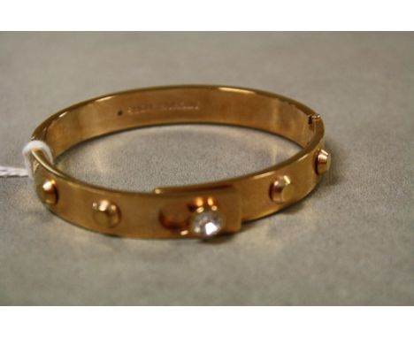 Hinged stone set Yellow metal bangle, marked to the inside "Michael Kors"