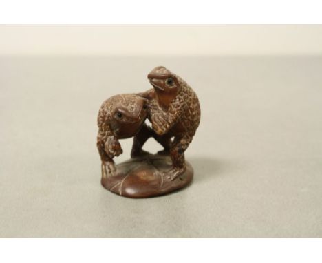 Vintage Wooden Netsuke in the form of a pair of Frogs, inset with Mother of pearl disc featuring Artists signature to base, a
