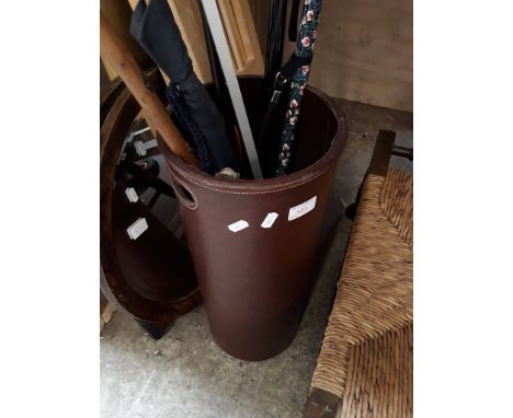 A LEATHER BOUND STICK STAND WITH WALKING STICKS AND BROLLYS