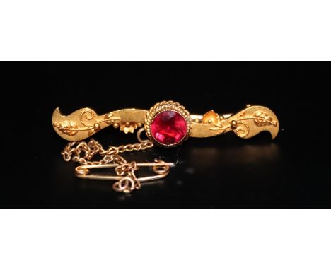 Victorian 15ct Gold Bar Brooch, Of Shaped Form With Applied Floral Decoration, The Center Set With A Single Ruby Blood Red Fa