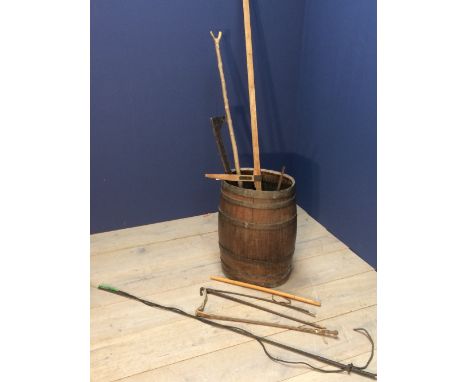 Old barrel stick stand with horse measuring sticks and other sticks, whips etc.