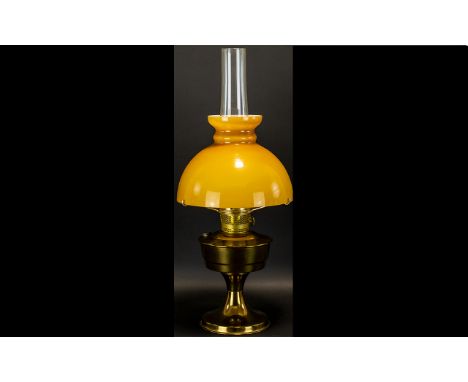 Brass Oil Lamp Of traditional form raised on circular base, complete with egg yolk yellow glass shade and clear glass chimney