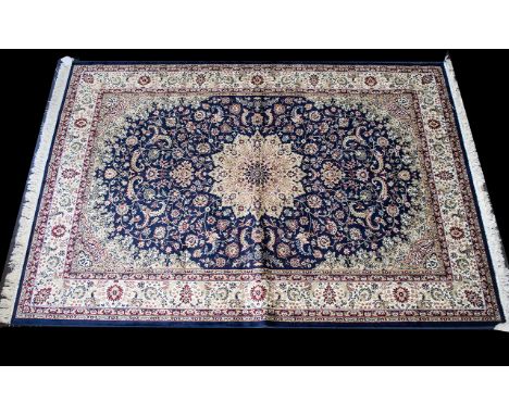 A Large Woven Silk Carpet Keshan rug with beige ground and blue border with traditional floral and foliate border detail with