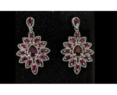 Ruby Ovoid Cluster Drop Earrings, each earring having a pear cut ruby surrounded by marquise cut rubies in a milgrain platinu