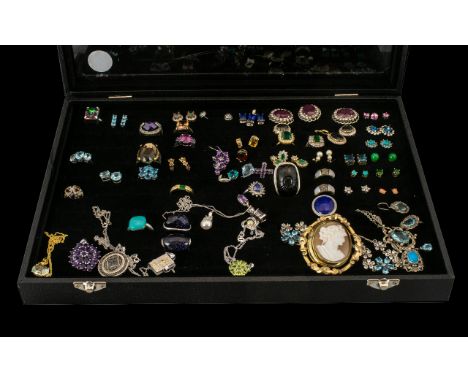 A Glazed Topped Showcase containing a collection of silver and costume jewellery. To include a quantity of gem set earrings, 