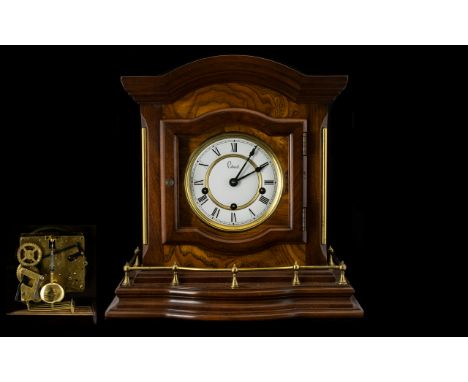 A Modern Mahogany Finish Chiming Mantle Clock white chapter dial with Roman Numerals. Three Chimes and silent mode. The back 