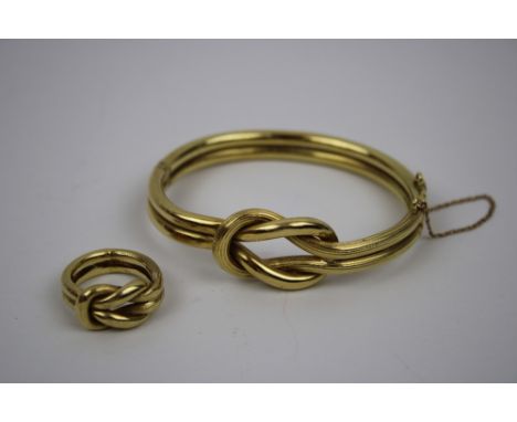A hinged Bangel and Ring, both with Herakles knot motif, stamped 750. Approx 39grams (2)