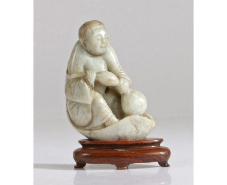 A Chinese jade figure of a boy, Qing Dynasty, 19th Century, carved seat on a lotus leaf petal clutching a gourd with both han