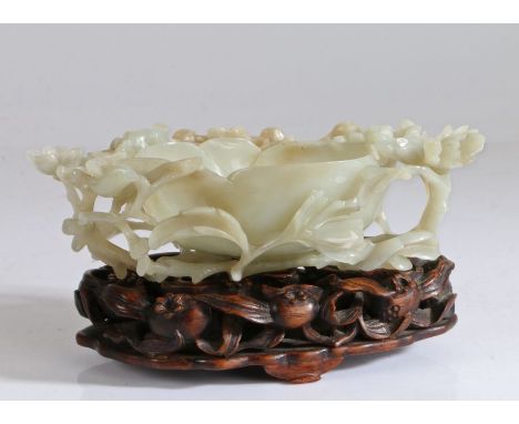 A Chinese jade water coupe, Ming Dynasty (1368-1644) elaborately carved in the form of a large flower forming the vessel and 