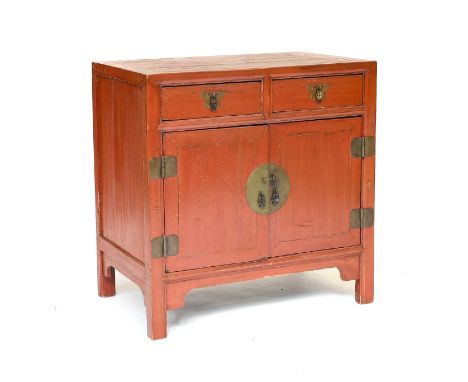 A Chinese Softwood Side Cabinet, 19th century, painted red, with two drawers above two cupboard doors enclosing a removable s