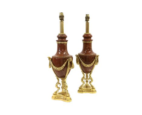 A Pair of Gilt Metal Mounted Rouge Marble Lamp Bases, in Louis XVI style, of urn shape hung with swags and loop handles, on t