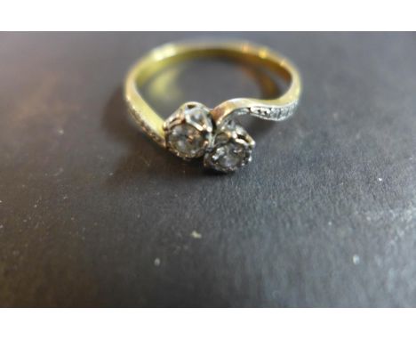 An 18ct gold and platinum diamond crossover ring set with two diamonds, approx 0.1cts each, in a platinum setting, ring not h