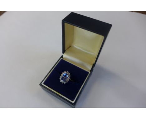 An 18ct gold cluster ring with a central cornflower blue stone, surrounded by small diamonds, marked 18ct, size K, approx 5 g