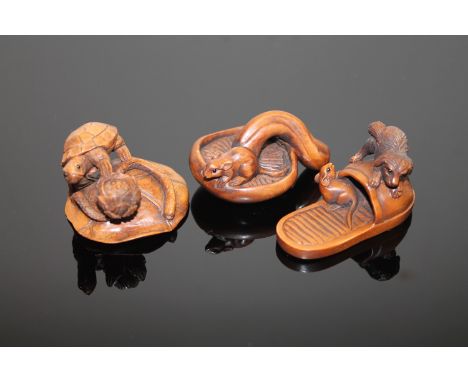 Three well carved Japanese boxwood netsuke depicting a rat on a mushroom, a tortoise on a lily pad and a dog chasing a rat on