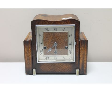 An Art Deco oak cased eight day mantel clock with silvered dial