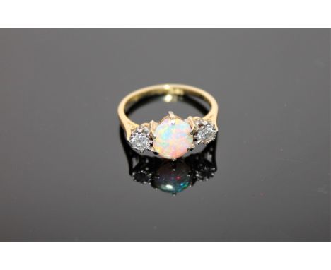 An 18ct gold opal and diamond three stone ring, size M