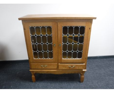 A continental light oak glazed door cabinet 