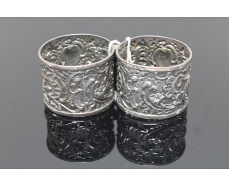 An ornate pair of silver napkin rings with putti playing drums (2)
