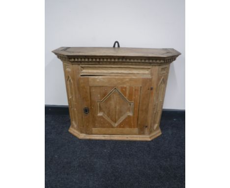 An antique light oak carved wall cabinet 