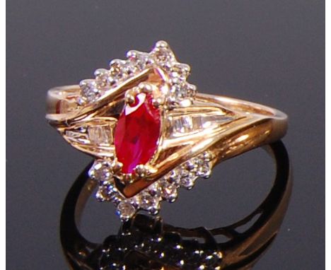 A 10ct gold, ruby and moissanite dress ring, arranged as a centre marquise cut and claw set ruby set to either side with seve